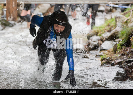 Bischofsheim, Allemagne. Mar 12, 2016. Les participants de la course extrême bataille Braveheart qui traverse un fleuve en Bischofsheim, Allemagne, 12 mars 2016. Près de 2 700 coureurs ont à gérer un 30 km avec 45 obstacles. Le extremerun mène à travers de l'eau très froide, la boue des fosses et feu chaud d'obstacles. Il est dit être l'un des plus difficiles en Europe. PHOTO : DANIEL KARMANN/dpa/Alamy Live News Banque D'Images