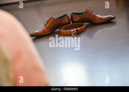 Chaussures en cuir marron ceinture et assis sur un plancher de bois Banque D'Images