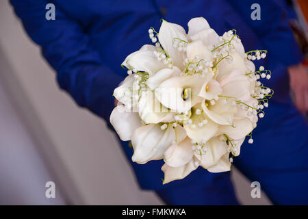 Groom holding fleur de lis calla blanc Banque D'Images