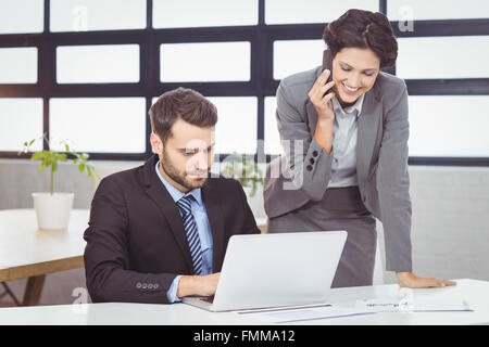 Les gens d'affaires avec téléphone portable et laptop in office Banque D'Images