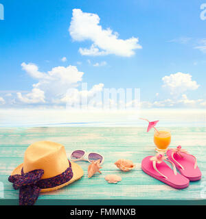 Accessoires de mode tongs de l'été, chapeau, lunettes bleu turquoise lumineux sur la plage du conseil Banque D'Images