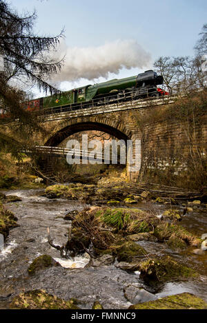 Goathland, North York Moors, UK. 12 mars, 2015. À la suite d'une £4,2 millions de révision, l'LNER Classe A3 "pacifique" le numéro de la locomotive à vapeur 60103 'Flying Scotsman' renvoie aux services aux passagers sur le North York Moors Railway. En pleine vapeur elle traverse Eller Beck pour son approche à Goathland station. Crédit : Dave Pressland/Alamy Live News. Banque D'Images