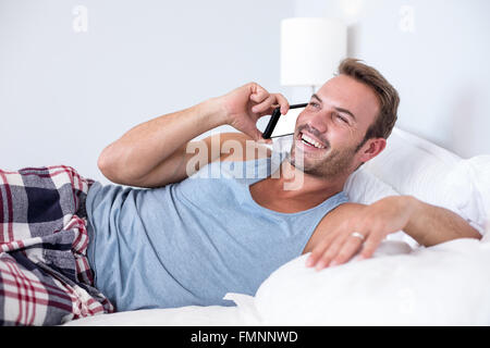 Young man lying on bed Banque D'Images