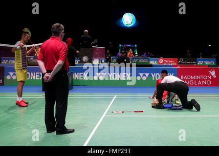 Birmingham. Mar 12, 2016. Xue Song (2e R) de la Chine reçoit un traitement médical alors que sa compatriote Lin Dan montre son inquiétude pour sa blessure au cours de la demi-finale du tournoi au 2016 YONEX All England Open Badminton Championships à Birmingham, Grande-Bretagne, le 12 mars 2016. © Han Yan/Xinhua/Alamy Live News Banque D'Images