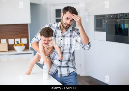 Père frustré holding crying baby boy Banque D'Images