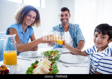 Portrait of family toasting verres de jus d'orange pendant le petit-déjeuner Banque D'Images