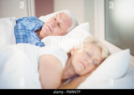High angle view of senior couple sleeping on bed Banque D'Images