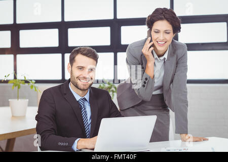 Les gens d'affaires avec téléphone portable et laptop in office Banque D'Images