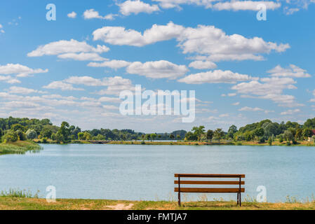 Banc vide près du lac sur une journée ensoleillée Banque D'Images