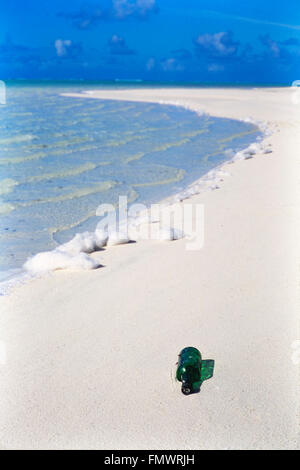 Bouteille de verre vert lavée à terre sur une plage immaculée des îles Cook dans l'océan Pacifique Sud Banque D'Images