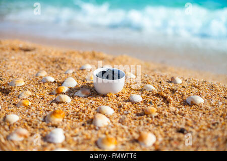 Boue de la mer morte pour les soins spa dans une tasse sur la plage Banque D'Images