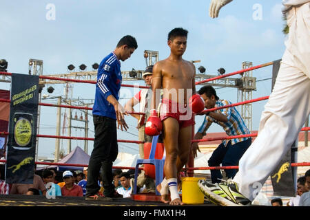 Un boxeur de Muay Thai quitte son coin après avoir été assisté d'entre les rondes dans un ring de boxe lors d'un festival Kampong Cham, Cambodge Banque D'Images