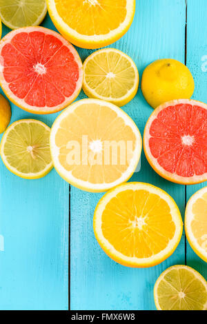 Citron, Orange, PAMPLEMOUSSE et CITRON Vert Agrumes tranches sur table Turquoise Banque D'Images