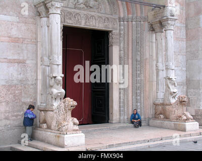 Deux mendiants en dehors de l'entrée en marbre à la Cathédrale de Ferrare. Banque D'Images