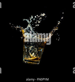 Shot de whiskey isolé avec splash sur fond noir Banque D'Images