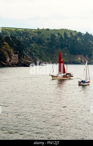 Deux petits bateaux à voile à croiser dans des directions différentes en face de la tour d'artillerie côtière de Kingswear Castle Banque D'Images