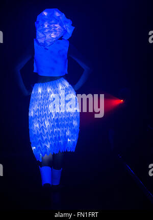 Un modèle marche à travers la passerelle pendant une blacklight fashion show pour l'ouverture de la 'lumière' Luminale spectacle à Offenbach, Allemagne, 12 mars 2016. Cette année, l'Luminale se déroule du 13 au 18 mars 2016 et dispose d'environ 200 installations de lumière à Francfort et d'Offenbach. Photo : BORIS ROESSLER/dpa Banque D'Images