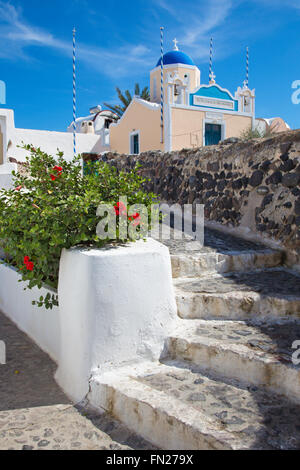 Santorin, GRÈCE - Octobre 5, 2015 : l'apparence belle maison décorée avec les fleurs et la petite église typiquement blanc-bleu Banque D'Images