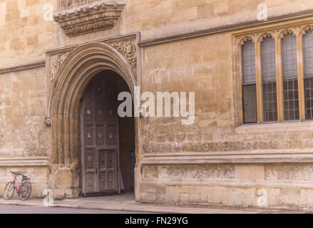 Une scène typique Oxford : un push bike appuyée sur l'entrée d'un collège, juxtaposant anciens et nouveaux, grandeur et simplicité. Banque D'Images