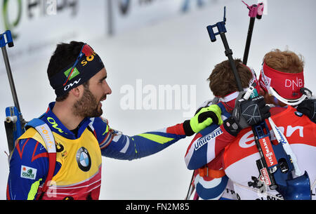 Le biathlète Martin Fourcade (L-R) de la France et de l'Ole Einar Bjoerndalen de la Norvège félicite le biathlète Johannes Thingnes Boe de la Norvège a remporté le concours 15km départ groupé aux Championnats du monde de biathlon, dans l'Arène de ski de Holmenkollen, Oslo, Norvège, 13 mars 2016. Photo : Hendrik Schmidt/dpa Banque D'Images