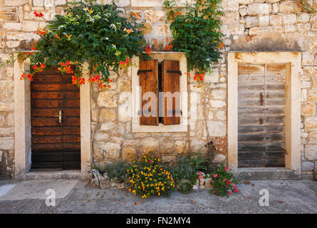 Façade de maison de pierre traditionnelle en bois avec porte et fenêtre dans la Dalmatie, Croatie. Banque D'Images