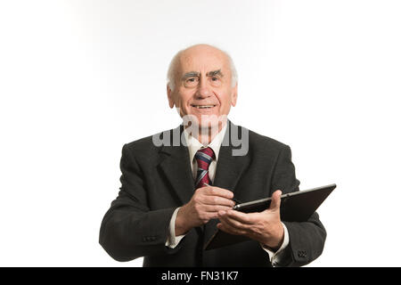 Ancien senior businessman travaillant avec l'ordinateur tablette noir, portant tailleur Banque D'Images