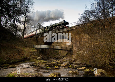 Goathland, North York Moors, UK. 13 mars, 2015. À la suite d'une £4,2 millions de révision, l'LNER Classe A3 "pacifique" le numéro de la locomotive à vapeur 60103 'Flying Scotsman' renvoie aux services aux passagers sur le North York Moors Railway. En pleine vapeur elle traverse Eller Beck pour son approche à Goathland station. Crédit : Dave Pressland/Alamy Live News. Banque D'Images