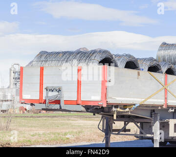 Les rouleaux de fils d'acier. Les rouleaux de fils d'acier de construction industrielle produits sur remorque de transport. Banque D'Images