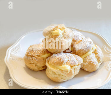 Profiteroles maison sur une plaque blanche. Banque D'Images