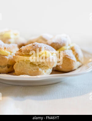 Profiteroles maison sur une plaque blanche. Banque D'Images