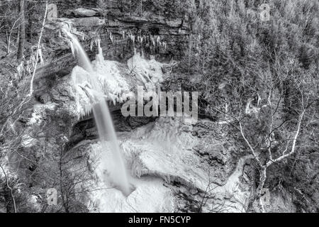 L'eau de la partie supérieure de Kaaterskill Falls dans une piscine au milieu de la glace dans les Catskills Mountains of New York. Banque D'Images