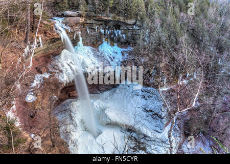 L'eau de la partie supérieure de Kaaterskill Falls dans une piscine au milieu de la glace dans les Catskills Mountains of New York. Banque D'Images