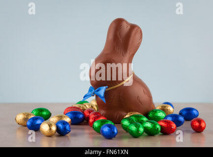 Les œufs en chocolat de Pâques colorés enveloppé dans du papier aluminium et Bunny. Profondeur de champ. Banque D'Images