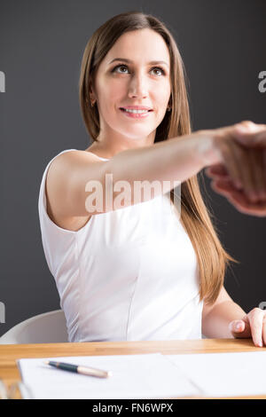 Young smiling business woman in white dress smart part donner à son partenaire. Happy businesswoman faire un deal avec partenaire masculin Banque D'Images