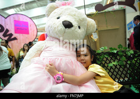 Bangkok, Thaïlande. 14Th Mar, 2016. Une jeune fille épouse un ours au cours de la poupée Ours Celebrity Show à un centre commercial à Bangkok, Thaïlande, 14 mars 2016. Ours Celebrity Show, une exposition présentant une collection d'images d'ours de renommée mondiale, n'est tenu à Bangkok du 11 au 20 mars. © Sageamsak Rachen/Xinhua/Alamy Live News Banque D'Images