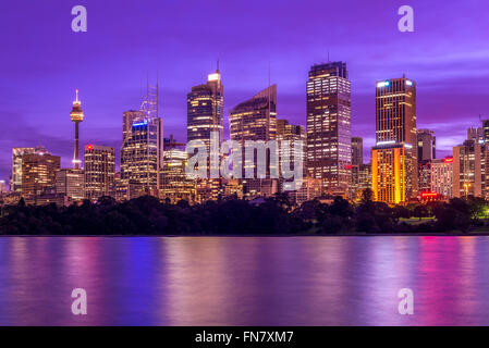 Ou CBD Central Business District de Sydney, en Australie au coucher du soleil avec relfections de lumières de la ville dans les eaux du port Banque D'Images