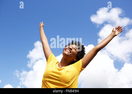 Portrait of young woman standing en dehors de ses mains posées sur sky Banque D'Images