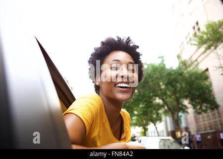 Portrait de jeune femme africaine à la recherche de la fenêtre de voiture dans la ville Banque D'Images