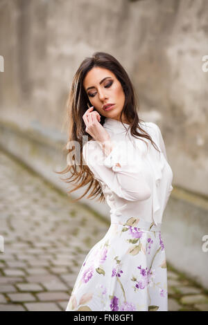 Femme d'affaires parle de téléphone. Jeune femme à la mode occupé avec son téléphone mobile. Portrait de jeune femme Banque D'Images