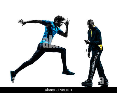 Un homme en sprintant avec coach chronomètre en silhouette studio isolé sur fond blanc Banque D'Images