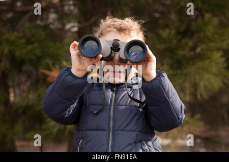 Boy looking through binoculars Banque D'Images