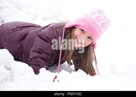 Smiling girl playing in snow Banque D'Images