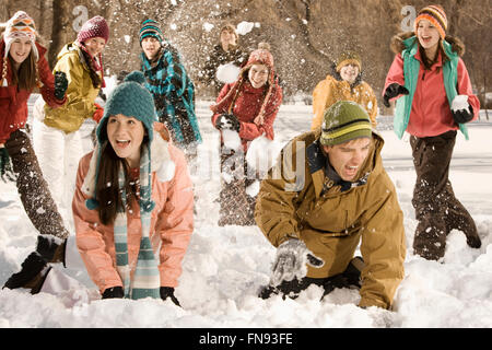 Un groupe d'enfants et de jeunes ayant une bataille de boules de neige.