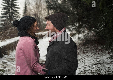 Couple standing in forest in snow Banque D'Images