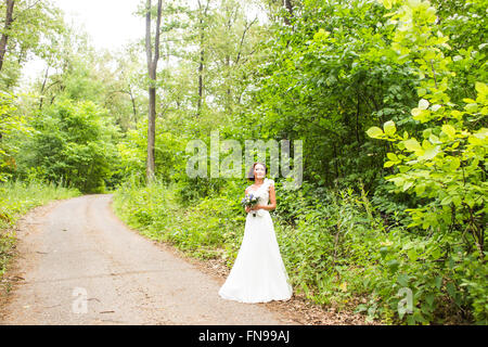 Bride holding bouquet de lis calla blancs et fleurs bleu Banque D'Images