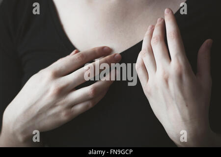 Close-up of woman's hands devant sa poitrine Banque D'Images