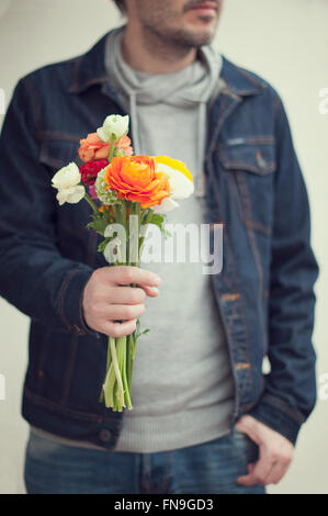 Man holding bunch of flowers Banque D'Images