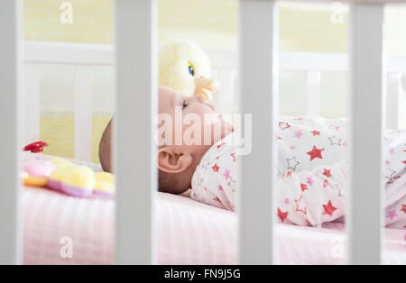 Baby Girl couché dans un lit bébé Banque D'Images