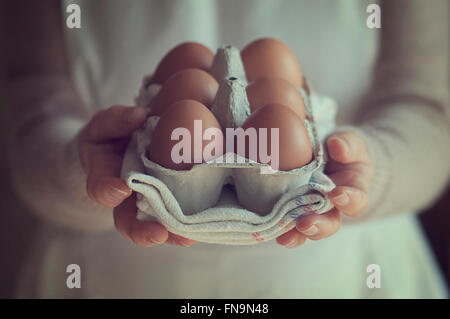 Mid section of a woman holding box d'oeufs Banque D'Images