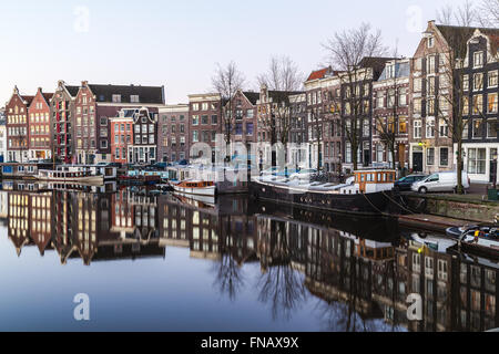 Vue le long du Canal Waalseilandgracht à Amsterdam dans la matinée. Des capacités, des bateaux et des réflexions peuvent être vus. Banque D'Images